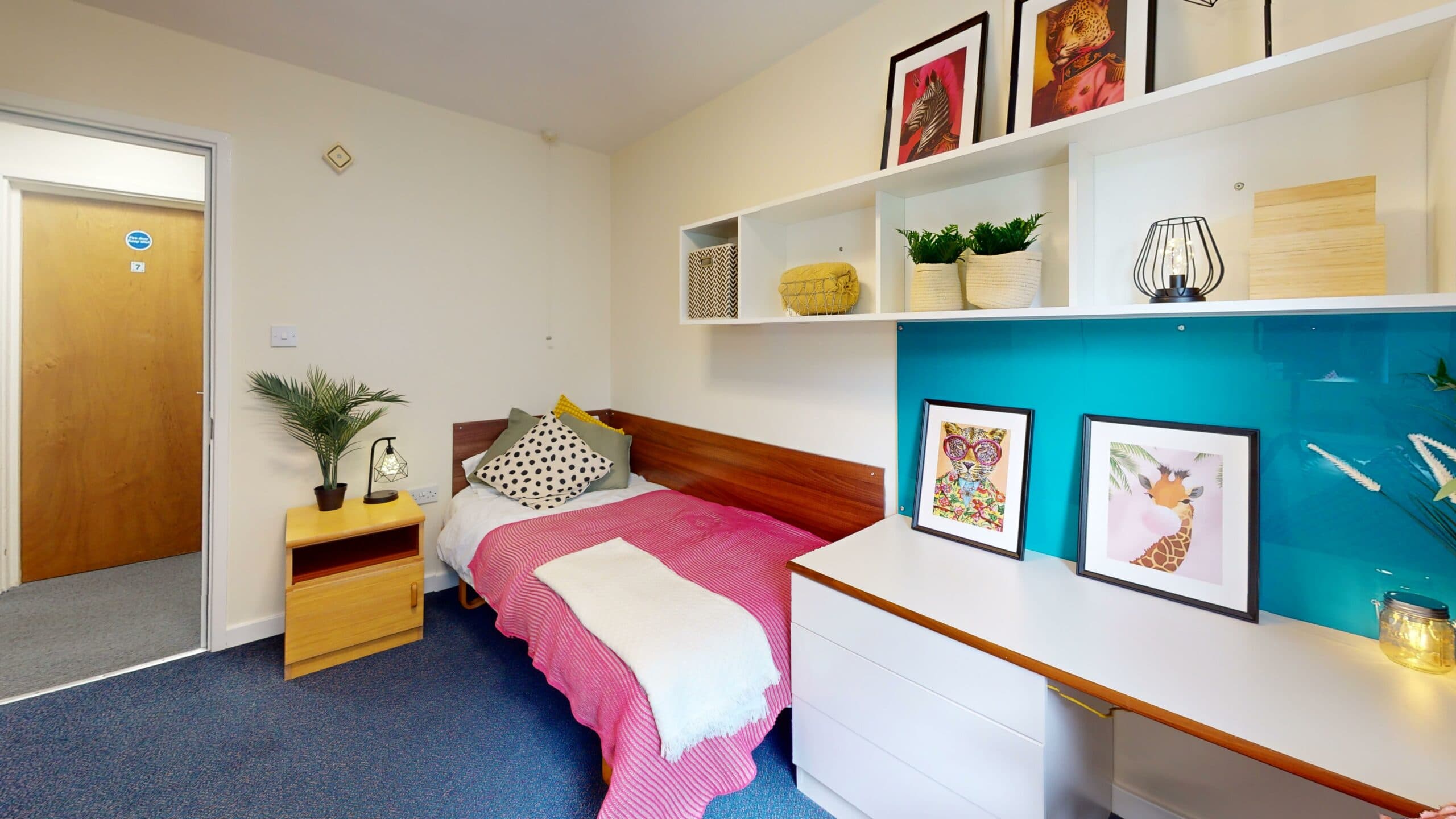 Standard bedroom at Cloister House with a bed, shelving and a picture wall